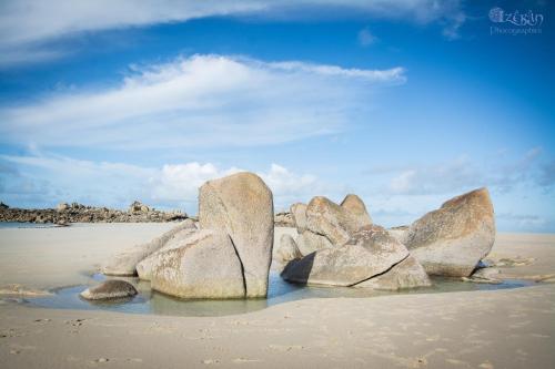 a group of large rocks on a sandy beach at Cap sur le Guillec in Sibiril