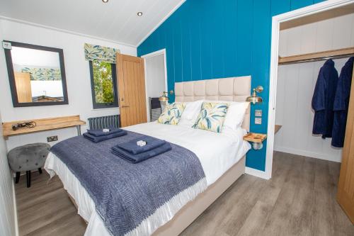 1 dormitorio con 1 cama con pared azul en Letham Feus Lodge and Caravan Park, en Fife