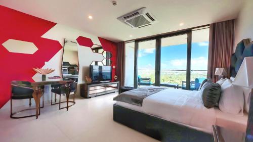 a bedroom with a large bed and a desk with a television at Mullet Bay Suites - Your Luxury Stay Awaits in Cupecoy