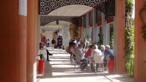 Un groupe de personnes assises à des tables sur un trottoir dans l'établissement maison noé , residence al quaria ab40, à Marrakech