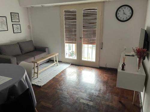 Una sala de estar con un sofá y un reloj en la pared. en Anita Home, en Santa Fe