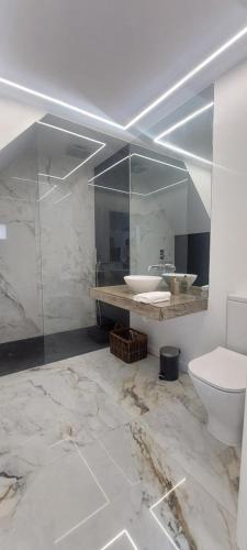 uma casa de banho branca com um lavatório e um WC em Seven no Funchal