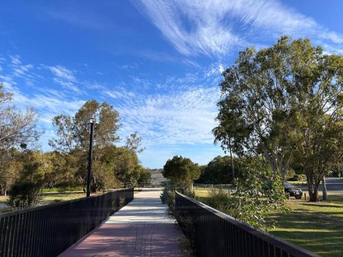 a walkway in a park with a fence and trees at Gardens by the Bay - Acreage Living & EV Charging in Deception Bay
