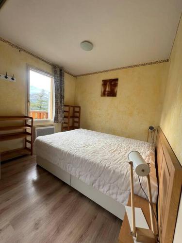 a bedroom with a bed and a window at Les terrasses d Isola B avec parking couvert inclus proche des pistes et de la galerie, résidence récente in Isola