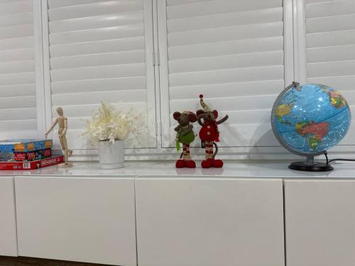 a counter with two figurines and a globe on it at Gardens by the Bay - Acreage Living & EV Charging in Deception Bay
