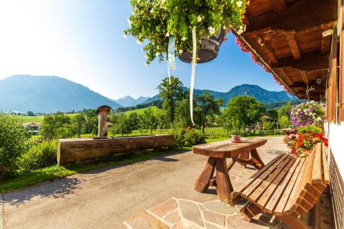 a wooden picnic table sitting next to a building at Langerbauer-Hof inkl. Chiemgaukarte in Ruhpolding