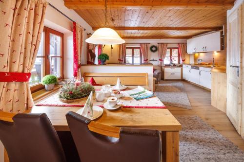 eine Küche und ein Esszimmer mit einem Holztisch in einem Zimmer in der Unterkunft Langerbauer-Hof in Ruhpolding