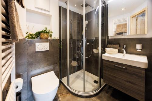 ein Bad mit einer Dusche, einem WC und einem Waschbecken in der Unterkunft Langerbauer-Hof in Ruhpolding
