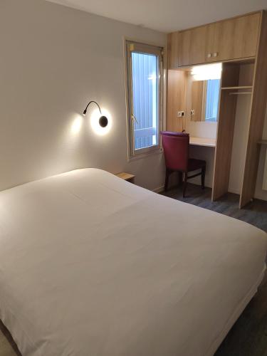 a large white bed in a room with a desk at FASTHOTEL PARIS OUEST BOUAFLE in Bouafle