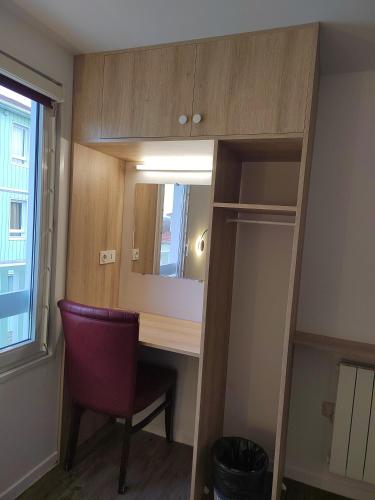 a room with a desk and a mirror and a chair at FASTHOTEL PARIS OUEST BOUAFLE in Bouafle