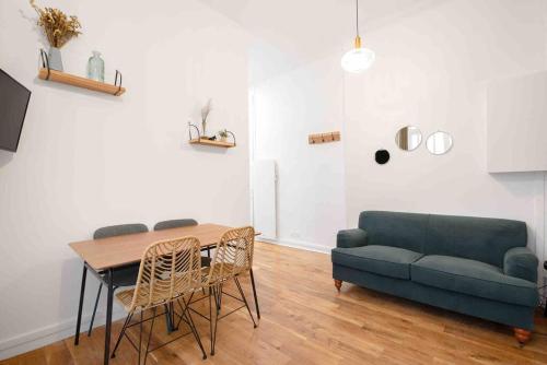 un salon avec une table et un canapé dans l'établissement MONTMARTRE, Gare de l'EST, suite 1 chambre 2 à 4P, à Paris