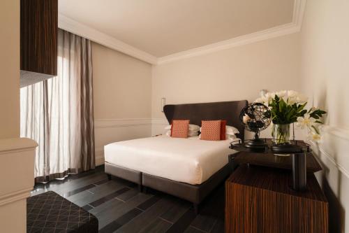sypialnia z łóżkiem i stołem z kwiatami w obiekcie Palazzo Navona Hotel w Rzymie