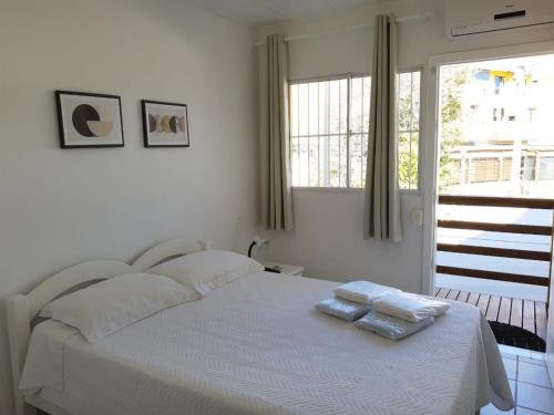 1 dormitorio con 1 cama con 2 toallas en Pousada Ingleses Beach en Florianópolis