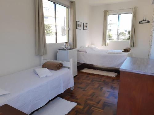 a room with two beds and two windows at Pousada Ingleses Beach in Florianópolis