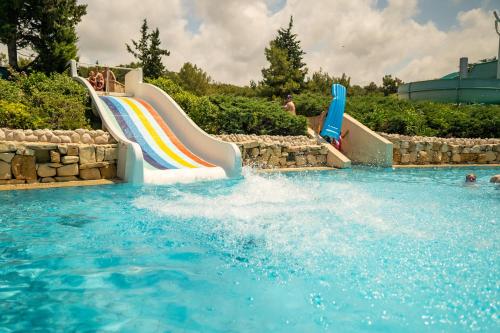 - un toboggan aquatique dans une piscine avec arc-en-ciel dans l'établissement AQI Pegasos Resort, à Avsallar