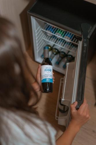 a little girl holding a bottle of wine in an open refrigerator at Andeluna Winery Lodge in Tupungato