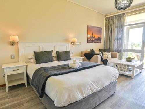 a bedroom with a large bed and a couch at Unit 261 Brookes Hill Suites in Summerstrand