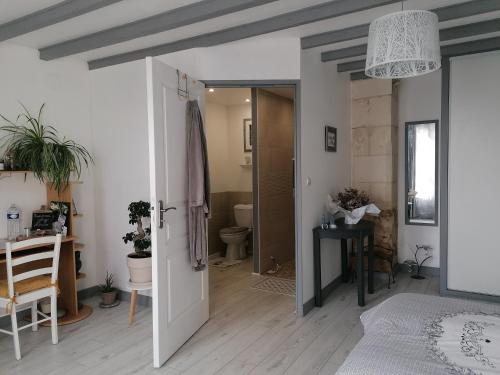 a bedroom with a door leading to a bathroom at Chez Mado in Thénac