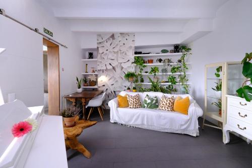 a living room with a white couch and some plants at Casa Caimari Guest House, for mountain lovers! in Caimari