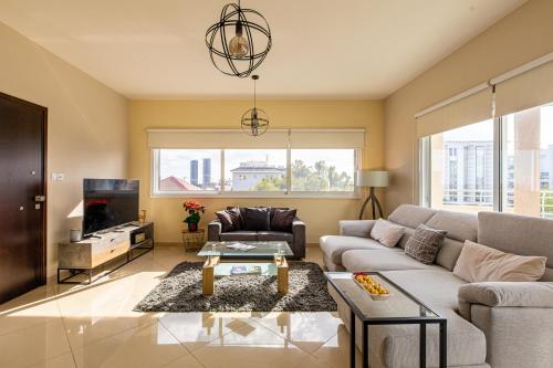 a living room with a couch and a tv at Central Bliss / your perfect home away from home in Limassol