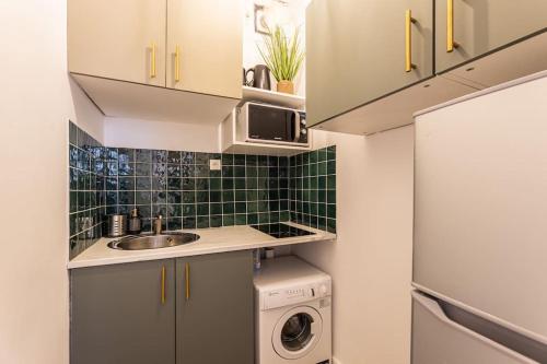 une petite cuisine avec un évier et une machine à laver dans l'établissement GARE DE LYON 12e, suite 1 chambre 2 à 4P, à Paris