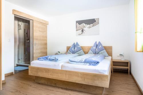 ミッタージルにあるOberhaidbachhofのベッドルーム1室(木製ベッド1台、青い枕付)