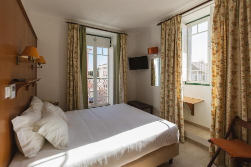 um quarto com uma cama e uma janela em Villa Marquez em Vila Real de Santo António
