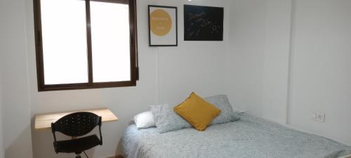 Dormitorio con cama con almohada amarilla en Villa Rosario en San Fulgencio