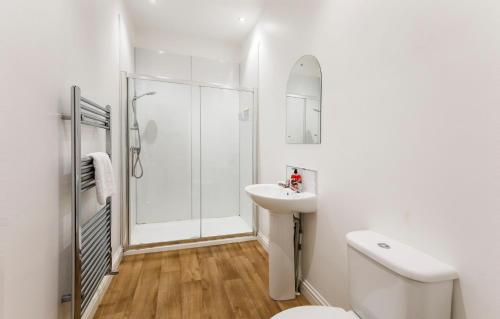 a white bathroom with a shower and a sink at Henry Court Apartment 4 in York