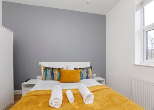 a white bedroom with a bed with towels on it at Henry Court Apartment 4 in York