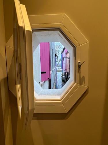 a mirror on a wall with a reflection of a street at Vanessa Home in Burano