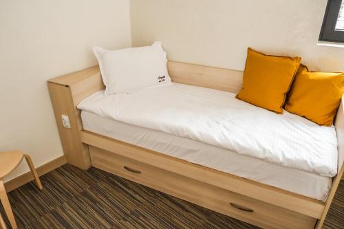 a bed in a small room with yellow pillows at Apartments Pavle in Kopaonik