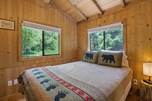 ein Schlafzimmer mit einem Bett in einem Holzzimmer mit Fenstern in der Unterkunft HTR Durango in Durango