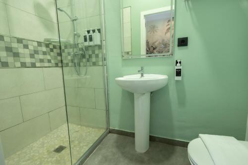 a bathroom with a sink and a glass shower at The Clover in Seville