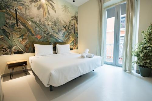 1 dormitorio con 1 cama grande y una pintura en la pared en The Clover, en Sevilla