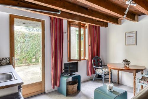 un salon avec une table et une fenêtre dans l'établissement Le Patio de la Bastide avec Terrasse & Netflix - Quartier paisible, à Carcassonne