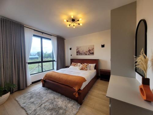 1 dormitorio con cama y ventana grande en Impala House, en Naivasha