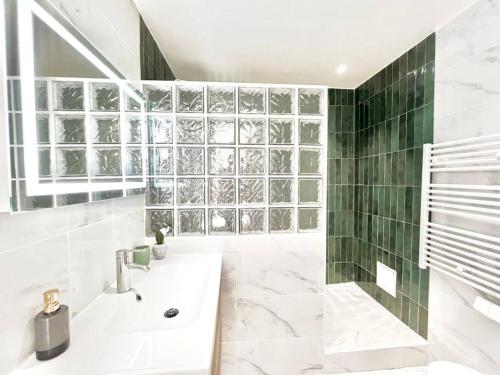 une salle de bain blanche avec un lavabo et une fenêtre dans l'établissement GRAND BOULEVARD, OPÉRA, suite 1 chambre 2 à 4P, à Paris