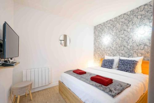 une chambre avec un grand lit blanc avec des oreillers rouges dans l'établissement GRAND BOULEVARD, OPÉRA, suite 1 chambre 2 à 4P, à Paris