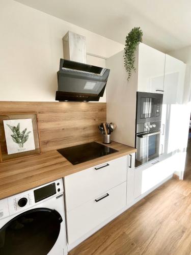 une cuisine avec un lave-linge et un sèche-linge sur un comptoir dans l'établissement Charmant studio + parking privé, à Caen
