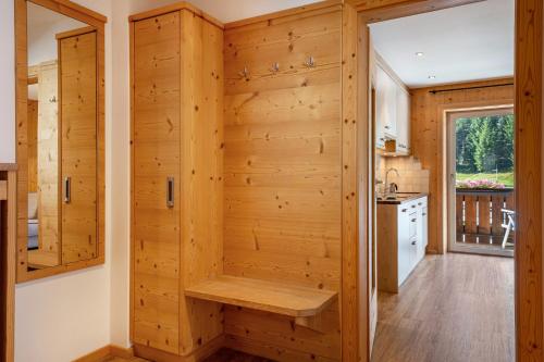 eine Küche mit einer Holzwand mit einer Bank in der Unterkunft Stoffel Apartments Marie in Selva
