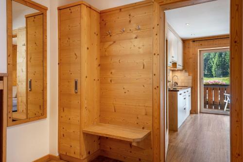 a kitchen with a wooden wall with a bench in it at Stoffel Apartments Marie in Selva