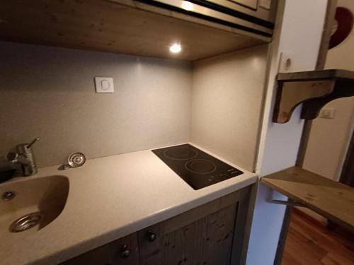 uma pequena cozinha com um fogão e um lavatório em Studio Résidence Glières em Bourg-Saint-Maurice