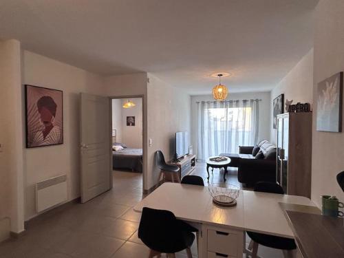 cocina y sala de estar con mesa y sillas en Joli appartement 3/4 personnes, en Saleilles