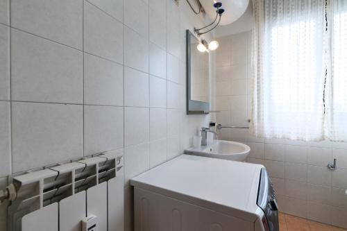 a white bathroom with a sink and a mirror at PrimoPiano - Saccardo in Milan