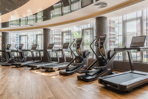 a row of treadmills in a gym with windows at Luxury Gated Apartment in Sofia