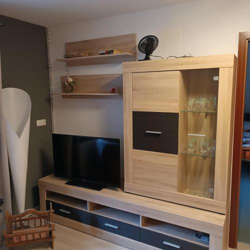 a wooden entertainment center with a flat screen tv at Ferienhaus Waldperle Harzblick in Wernrode