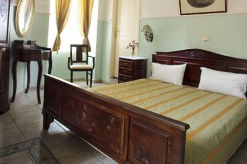 um quarto com uma cama, uma secretária e uma cadeira em monte kristo em Ermoupoli