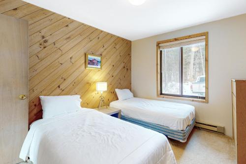 1 dormitorio con 2 camas y ventana en Vermont Country Ski House, en Vermont Ventures