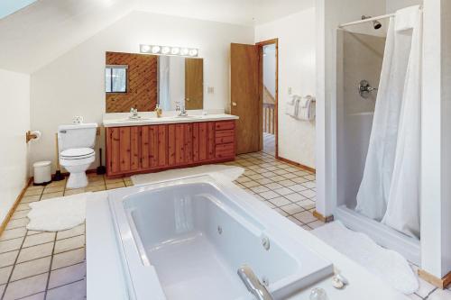 een badkamer met een bad, een wastafel en een toilet bij Vermont Country Ski House in Vermont Ventures